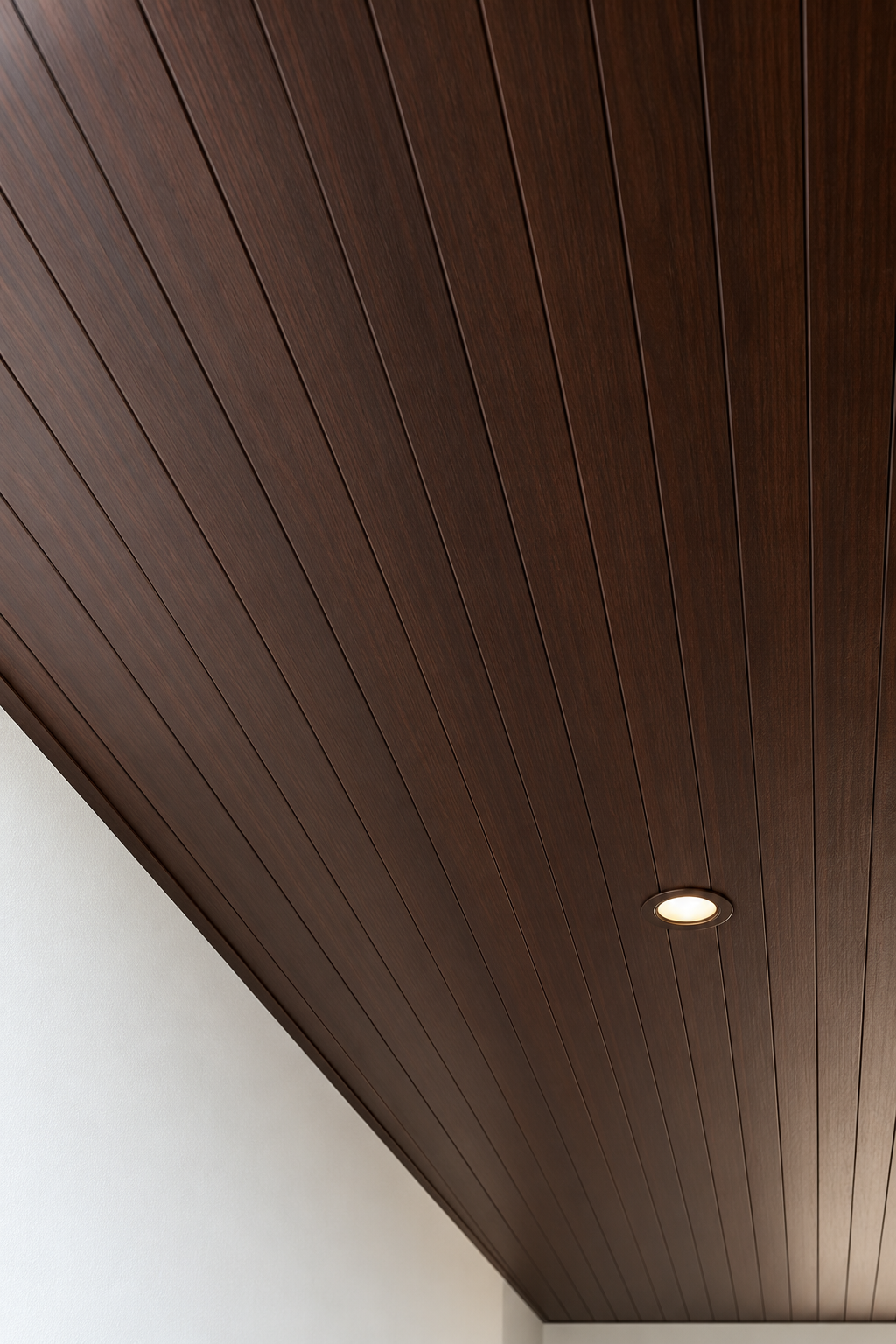 Illustration of a downlight set into a dark Walnut woodgrain PVC ceiling, with the strip lines running towards the wall